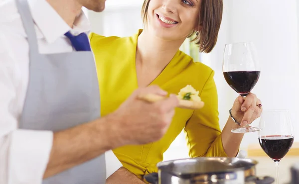 Attractive couple in love cooking and opens the wine in the kitchen while they cook dinner for a romantic evening — Stock Photo, Image