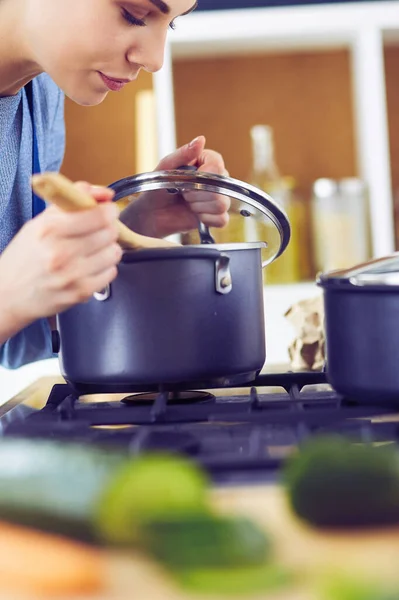 Mujer cocinera en cocina con cuchara de madera — Foto de Stock