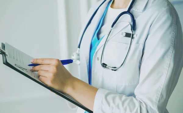 Woman doctor standing with folder at hospital — Stock Photo, Image