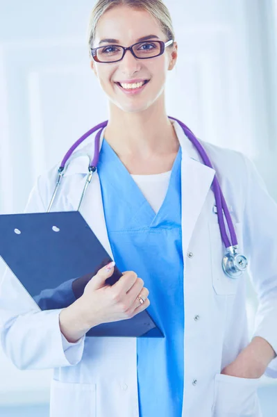 Médico sonriente con una carpeta en uniforme de pie —  Fotos de Stock