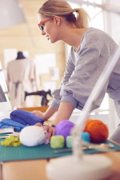 Junge attraktive Modedesignerinnen lehnen am Schreibtisch im Büro und arbeiten mit einem Laptop — Stockfoto