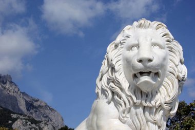 Mavi gökyüzü arka plan üzerinde mermer aslan tehditkar.