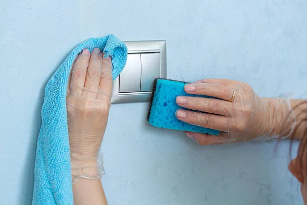 Woman hands in vinyl gloves with blue sponge and wipe for housekeeping.