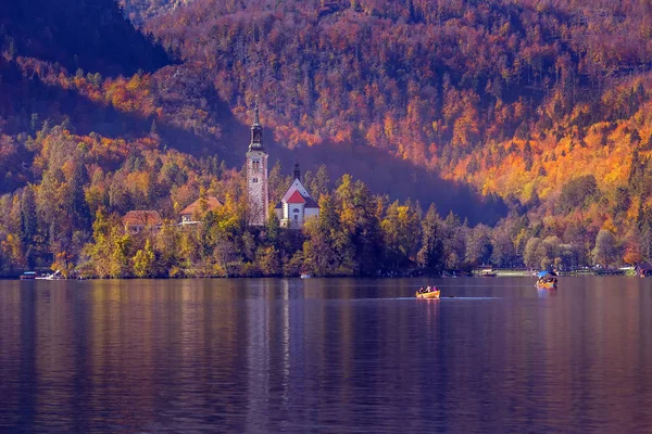 Bled, Slovénie bateau et église au coucher du soleil — Photo