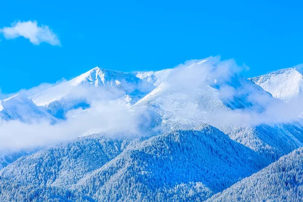 Bergstoppar och blå himmel med moln bakgrund — Stockfoto