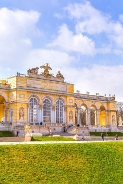Viyana, Austia - 3 Nisan 2015 Schonbrunn Palace Garden 'daki Gloriette bulutlu mavi gökyüzüne karşı. Etrafta dolaşan turistler.