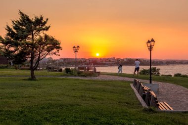 Nessebar, Bulgaristan - 14 Eylül 2020: Fotoğraf çeken çift, altın gökyüzü ve eski geleneksel evler, fenerler