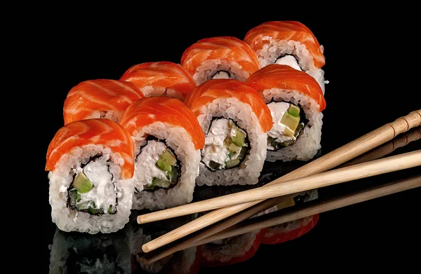 Sushi roule Philadelphie avec des baguettes Images De Stock Libres De Droits