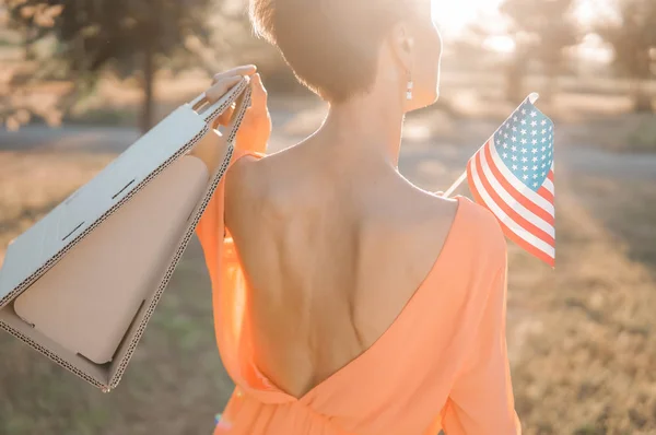 Vacker Kvinna Med Papperspåse Eller Nuvarande Innehav Amerikanska Flaggan Utomhus — Stockfoto