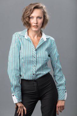 Bir gömlek ve pantolon gri arka plan üzerinde atış studio izole kadın