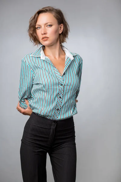 Woman in a shirt and pants isolated over gray background, studio shot