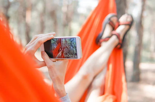 Día Verano Mujer Joven Acostada Hamaca Naranja Parque Usando Teléfono —  Fotos de Stock