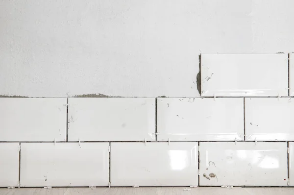 Tiling the tiles in the kitchen. Ceramic brick tile wall in process