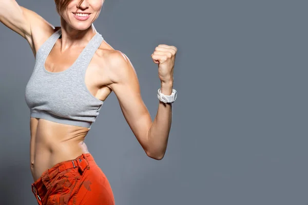 Sportive Kobieta Pokazując Mięśnie Szarym Tle — Zdjęcie stockowe