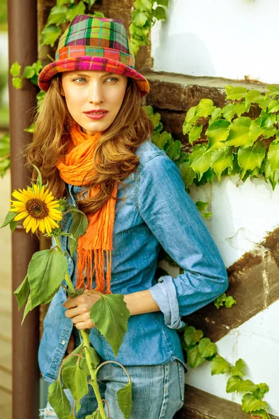 大気のアウトドアの帽子とオレンジ色のスカーフを身に着けている素敵な女性の写真 茶色の毛 暖かい秋の色 季節イメージ — ストック写真