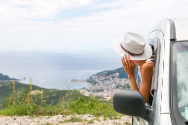 Bir araba şehir ve deniz, pencereden dışarı arayan genç bir kadın
