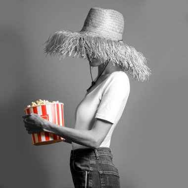 Moda gıda fotoğraf. Patlamış mısır yemek kadın. Siyah beyaz görüntü parlak beyaz kırmızı çizgili kağıt torba patlamış mısır tam ile