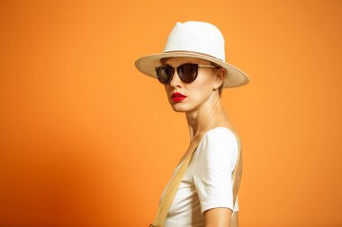 Şık kadın bir şapka ve güneş gözlüğü, aksesuarlar, stüdyoda canlı renk arka plan üzerinde poz alanı kopyalayın. Moda yaz veya sonbahar fotoğraf