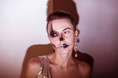 Cadılar Bayramı. Gri arka plan üzerinde izole parlak siyah Cadılar Bayramı makyaj ile güzel bir kadın. tonda kırmızı arka plan