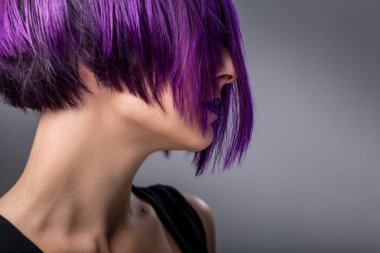 Gri arka plan üzerinde mor kısa saçlı kadın moda