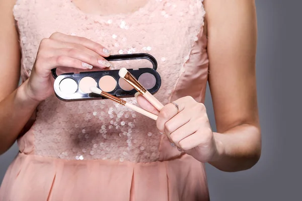 Sombra Pinceles Maquillaje Sosteniendo Por Mujer Sobre Fondo Vestido Rosa — Foto de Stock