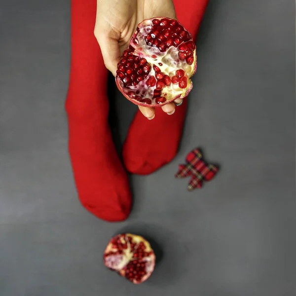 Ripe pomegranate fruit in woman hands, top view