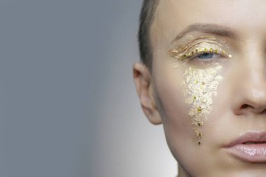 Altın makyaj gözyaşları, ayrıntı, yan yüzü gibi güzel bir kadınla