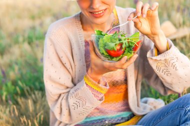 Genç kadın güzel manzara ile salata yemek