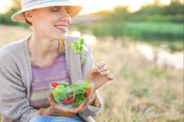 Genç kadın güzel manzara ile salata yemek