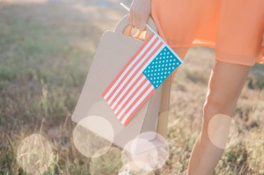 Anma Günü satış, Bağımsızlık Günü Satılık. Kadın el kağıt torba ve bahar ya da yaz Park Amerikan bayrağı