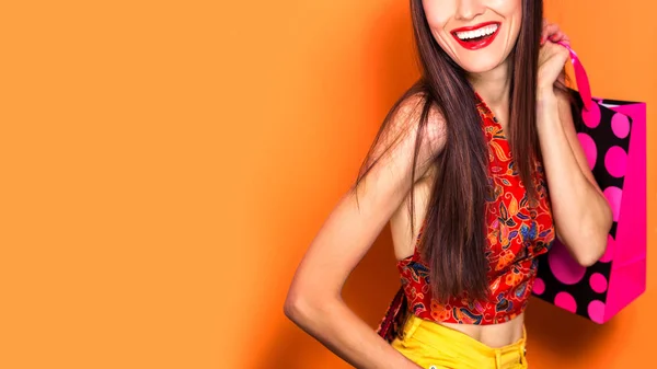 Jonge Winkelvrouw Met Boodschappentassen Oranje Zomerachtergrond — Stockfoto