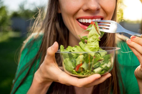 Schöne Kaukasische Frau Isst Salat Über Grünen Natürlichen Hintergrund — Stockfoto