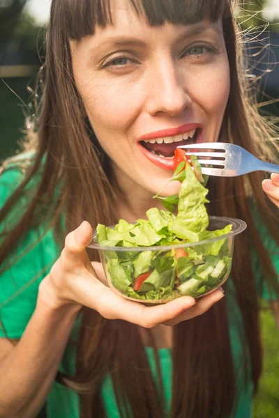 Hermosa Mujer Caucásica Comiendo Ensalada Sobre Fondo Verde Natural — Foto de Stock