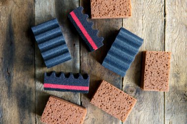 Temizlik Günü Konsept Süngerler, ahşap arka plan üzerinde siyah ve kahverengi temizlik süngerleri