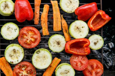 Yaz veya ilkbahar pikniminde açık havada hazırlanan sağlıklı yiyecekler. Kömürlerde ızgara sebzeler. Çayırda barbekü pikniği