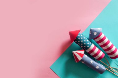 4 Temmuz tatil alışveriş konsepti. Pembe arka plan üzerinde ulusal amerikan renkleri ve havai fişek roketler alışveriş çantaları