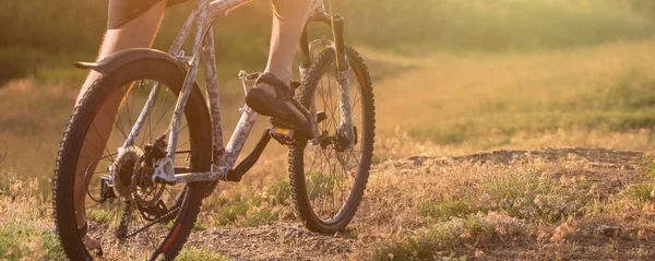 日落时骑自行车的人骑自行车沿着岩石山走 关闭极限运动理念 — 图库照片