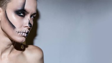 Cadılar Bayramı. Gri arka plan üzerinde izole parlak siyah Cadılar Bayramı makyaj ile güzel kadın