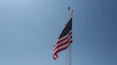Mavi gökyüzü önünde rüzgar sallayarak Amerikan bayrağı