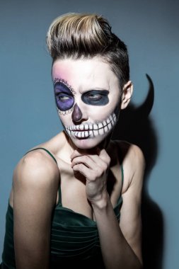 Halloween. Parlak siyah halloween makyaj ile güzel kadın , koyu gri arka plan üzerinde izole boynuzları ile saç modeli ve gölge
