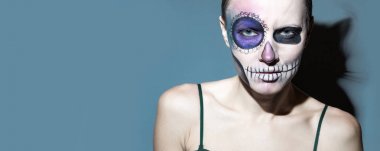 Halloween. Parlak siyah cadılar bayramı makyaj ve gri arka plan üzerinde izole arkasında bir kedi şeklinde bir gölge ile güzel kadın