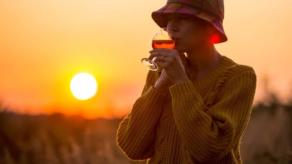 オレンジ色のアペロール 赤ワイン グラスを飲む美しい秋の女性が夕日を見て 豪華なライフスタイルバナーパノラマ風景 — ストック写真