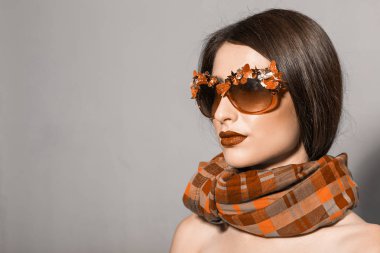 Lüks sonbahar moda aksesuarlarında poz veren zarif bir kadın.