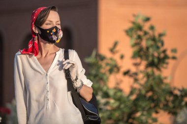 Coronavirus salgını karantinası sırasında moda kıyafetli bir kadın. Karantina şehri yaşam tarzı, koruyucu maske ve eldiven takan genç bir kadın.
