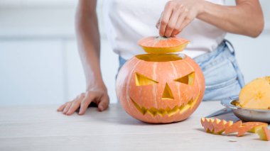 Beyaz mutfakta oyulmuş yüzlü turuncu cadılar bayramı balkabağı, tatil süsü.