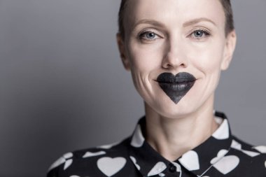 Alışılmadık makyajlı, dudaklarında siyah bir kalp olan güzel bir genç kadın. siyah ve beyaz