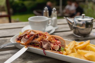 Gündelik yemek, piknik havası, öğle yemeği fikri. Yemek blogları ve açık hava yemekleri için mükemmel. Sandviç ve kızarmış patatesle dışarıda hızlı bir öğle yemeği.