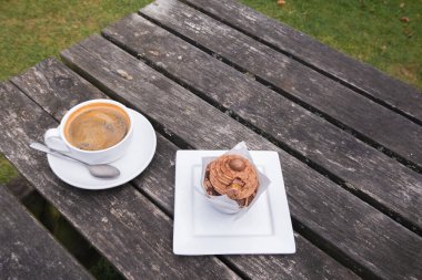 Relaxing break with coffee and cake outside. Sweet indulgence. Suitable for lifestyle, hospitality photography. Cozy break. Single in a quiet landscape