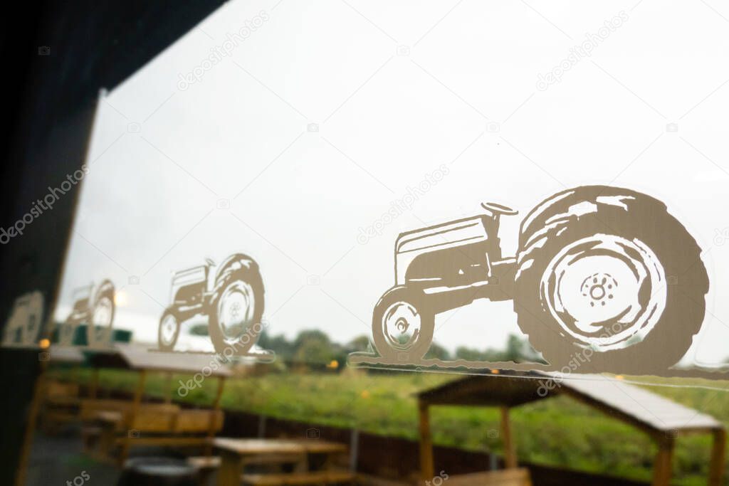 Northumberland, United Kingdom- September, 20, 2025: Brocksbushes farm shop concept image with tractor sticker on a window with countryside  on the background. Rural farm lifestyle scene