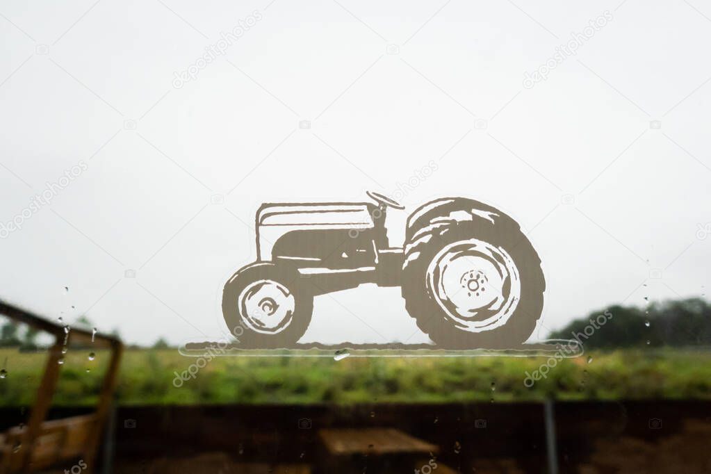 Northumberland, United Kingdom- September, 20, 2025: Brocksbushes farm shop concept image with tractor sticker on a window with countryside  on the background. Rural farm lifestyle scene